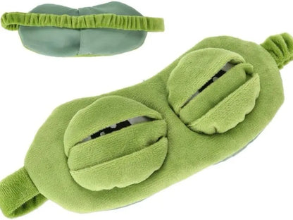 Frog Sleep Mask — A stylish, shimmering sleep mask featuring an adorable "Sad Frog" design. This fun, plush eye mask is perfect for travel, yoga, napping, and light-blocking; its soft cotton lining gently cares for sensitive skin.